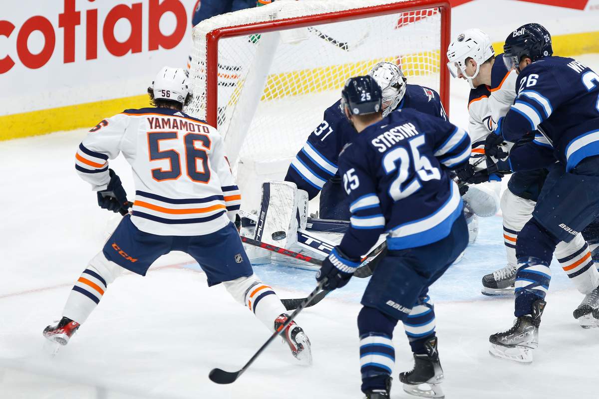 Edmonton Oilers’ Kailer Yamamoto (56) scores against Winnipeg Jets goaltender Connor Hellebuyck (37)during second period NHL action in Winnipeg, Saturday, Feb. 19, 2022.