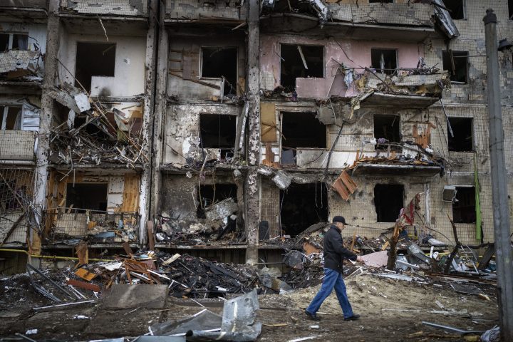 A man walks past a building damaged following a rocket attack the city of Kyiv, Ukraine, Friday, Feb. 25, 2022.
