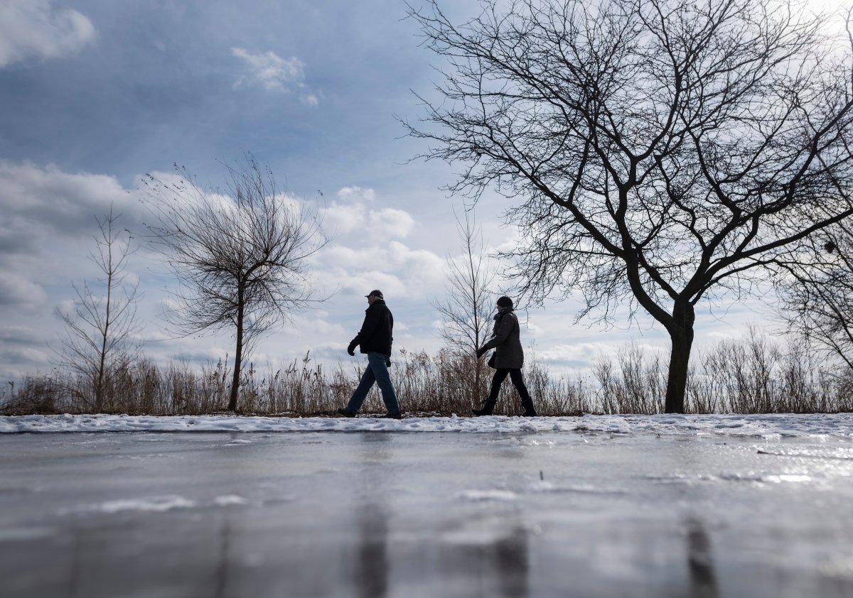 People walk along the waterfront trail near the Sunnyside Park area in Toronto, Saturday, Feb. 15, 2020. 