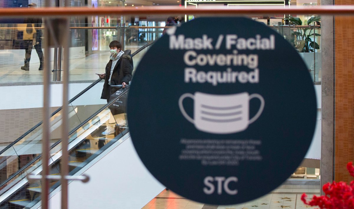 TORONTO, Feb. 4, 2022  A man wearing a face mask is seen behind a sign reminding people to wear face masks at a shopping center in Toronto, Ontario, Canada, on Feb. 4, 2022.