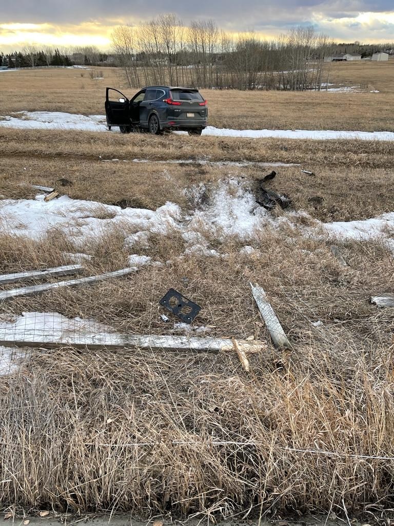 A black Honda CRV and damaged fencing