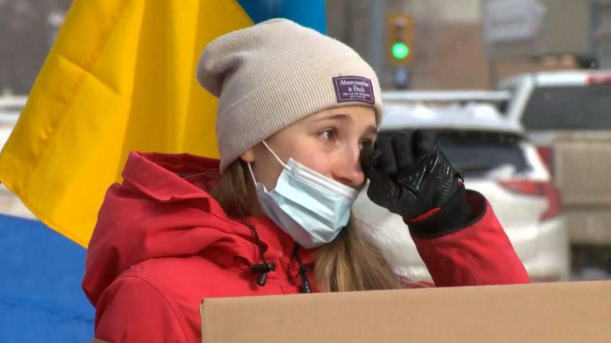 A Calgarian wipes away tears at a pro-Ukraine rally at city hall Feb. 24, 2022.