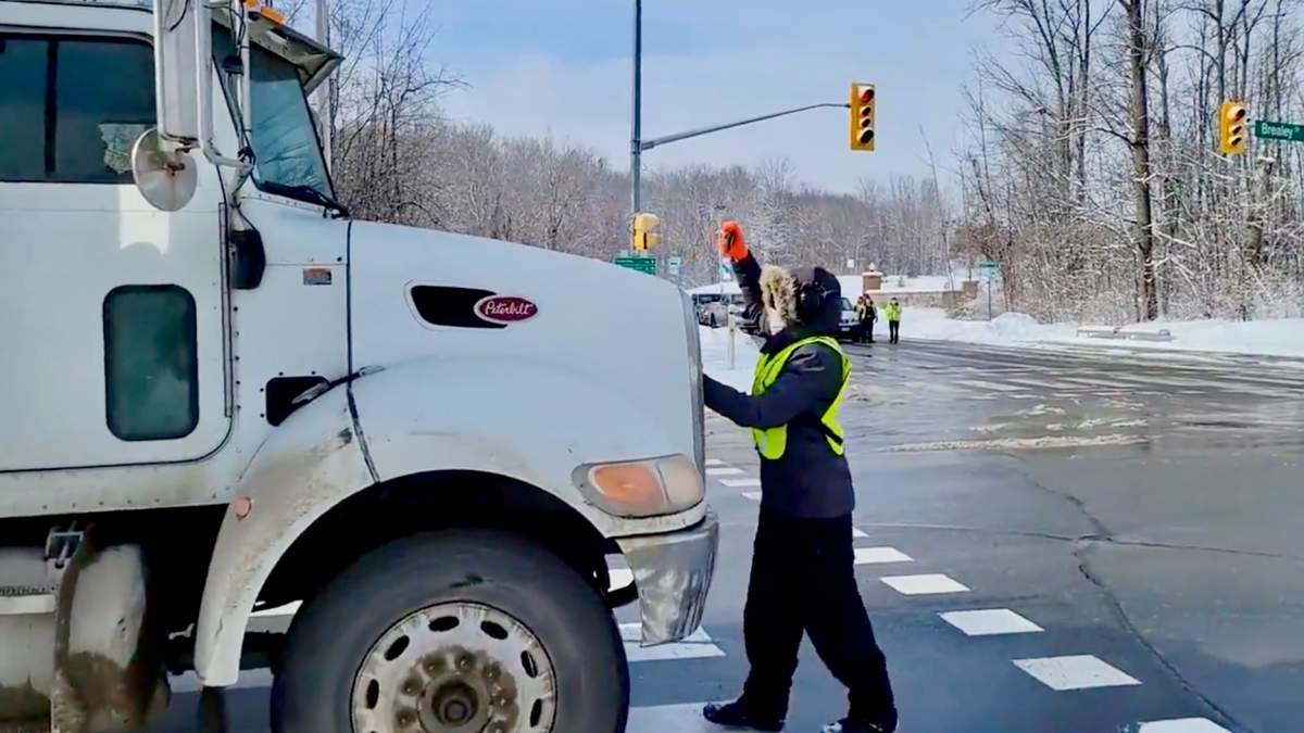 A transport truck drives slowly pushed a man forward on Brealey Drive in Peterborough on Feb. 19, 2022.