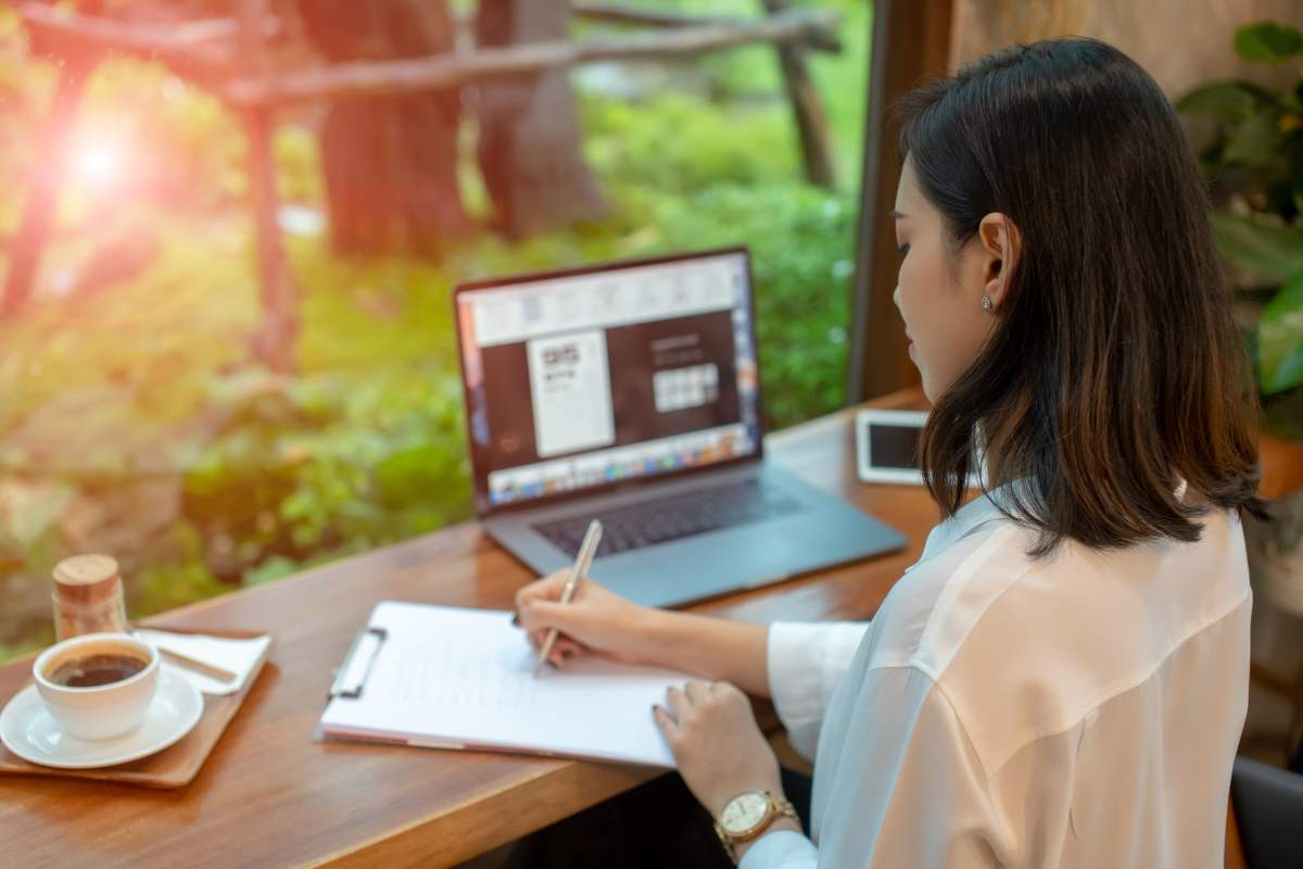 Asia women are sitting thinking and writing with pen and open notebook in cafe. Journalist and writer concept. Business lifestyle.Education concept.Business Woman with cup of coffee.