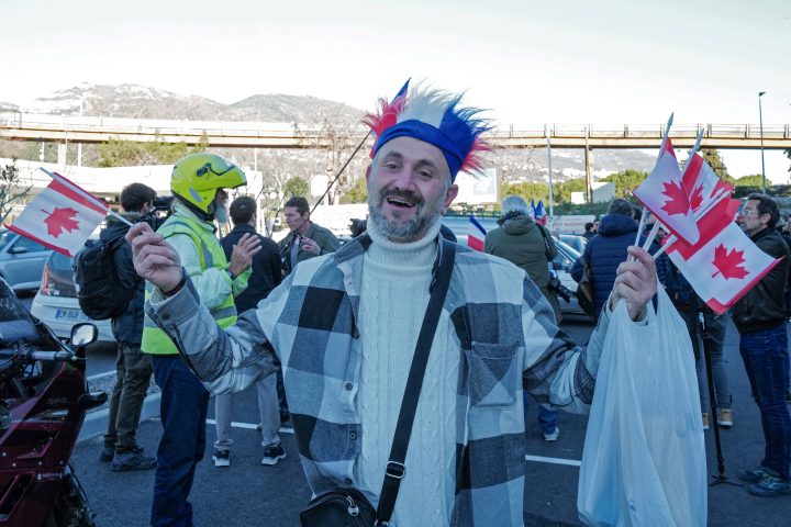A man waves Canadian flags as he prepares to take part in the “freedom convoy” in Nice, southeastern France, on Feb. 9, 2022. –