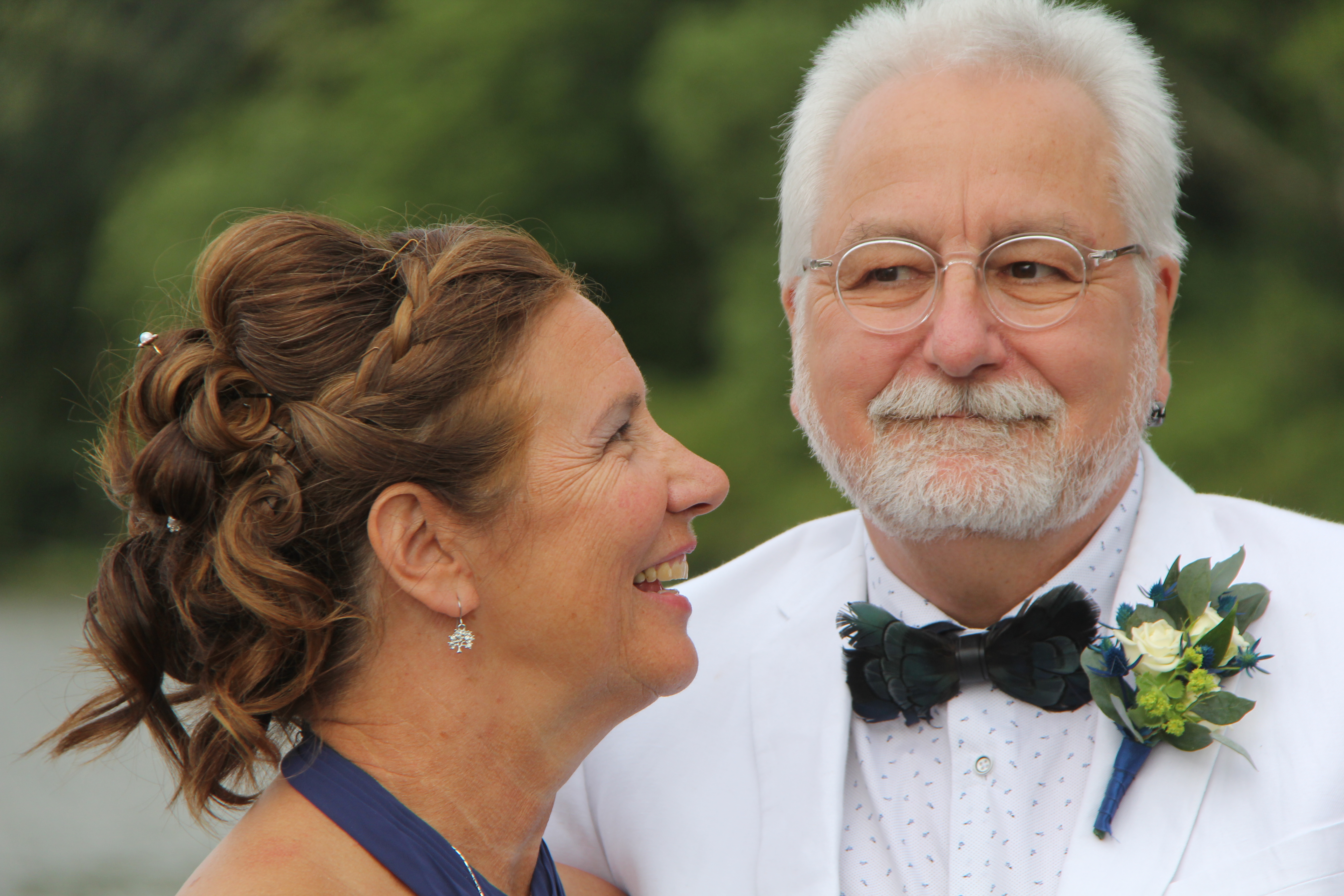 A bride is looking at her groom on their wedding day, both people are smiling.