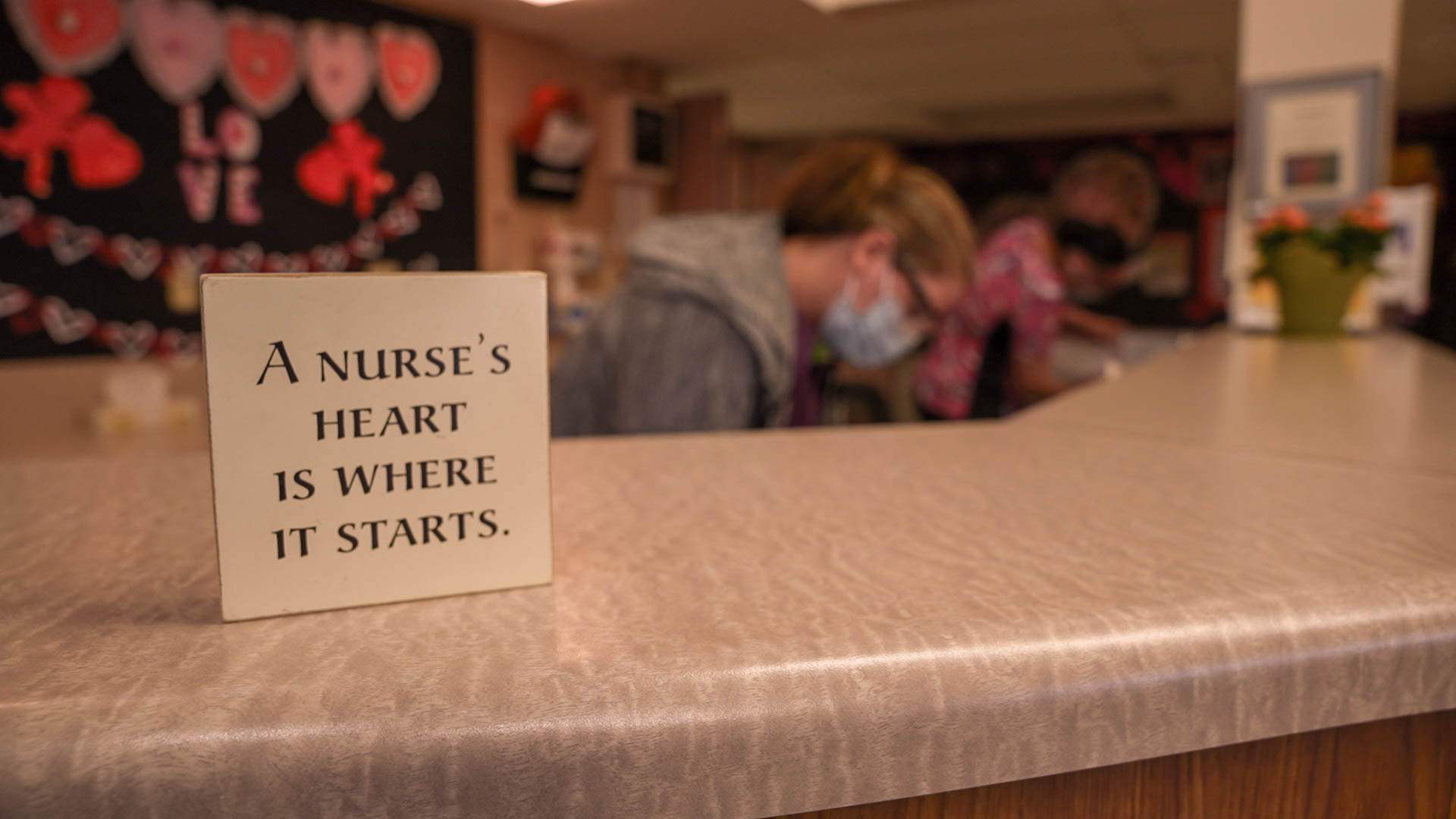 A sign at a nursing station within Menno Place reads 'a nurse's heart is where it starts.'