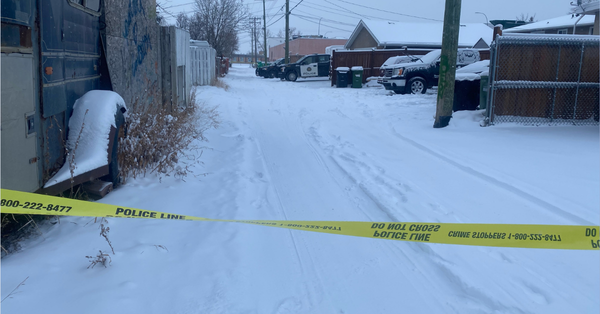 Calgary police tape shown in a snowy back alley on Feb. 21, 2022.