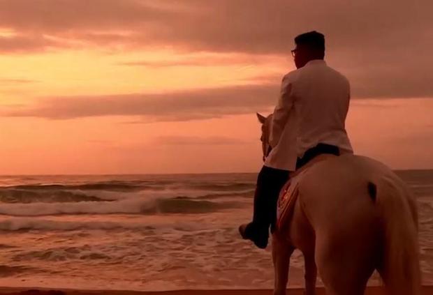 Kim Jong Un startes out to sea while on a white horse.