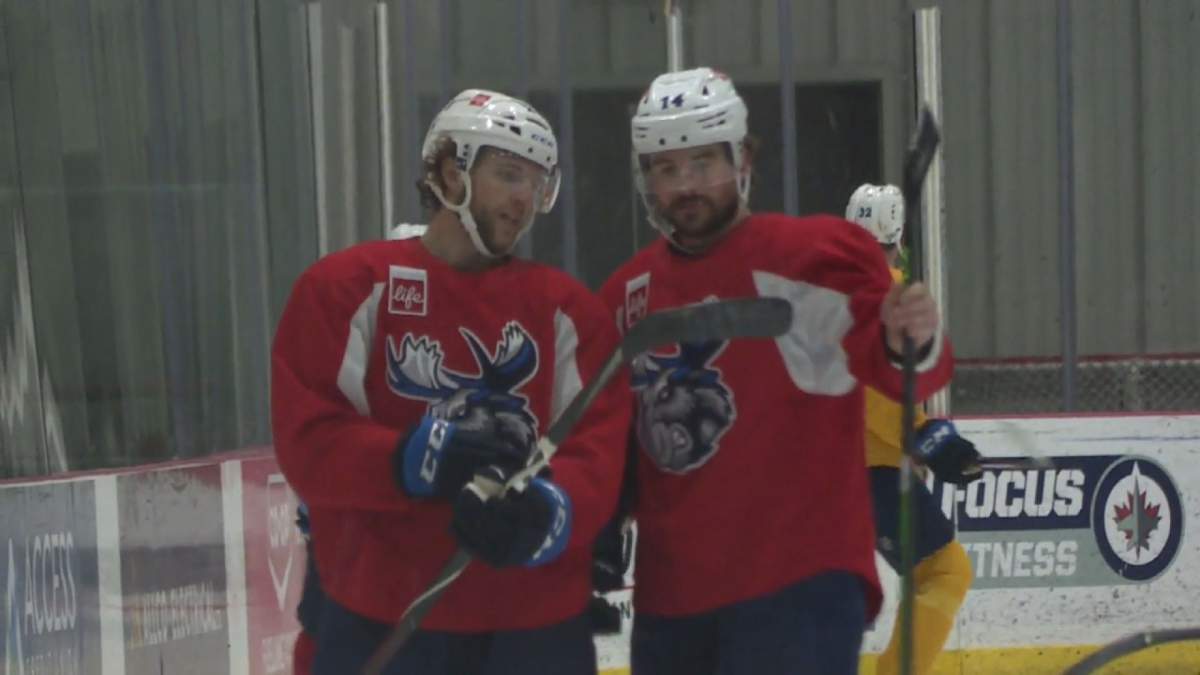 Manitoba Moose captain Jimmy Oligny chats with teammate and fellow defenceman Hayden Shaw during a recent practice.