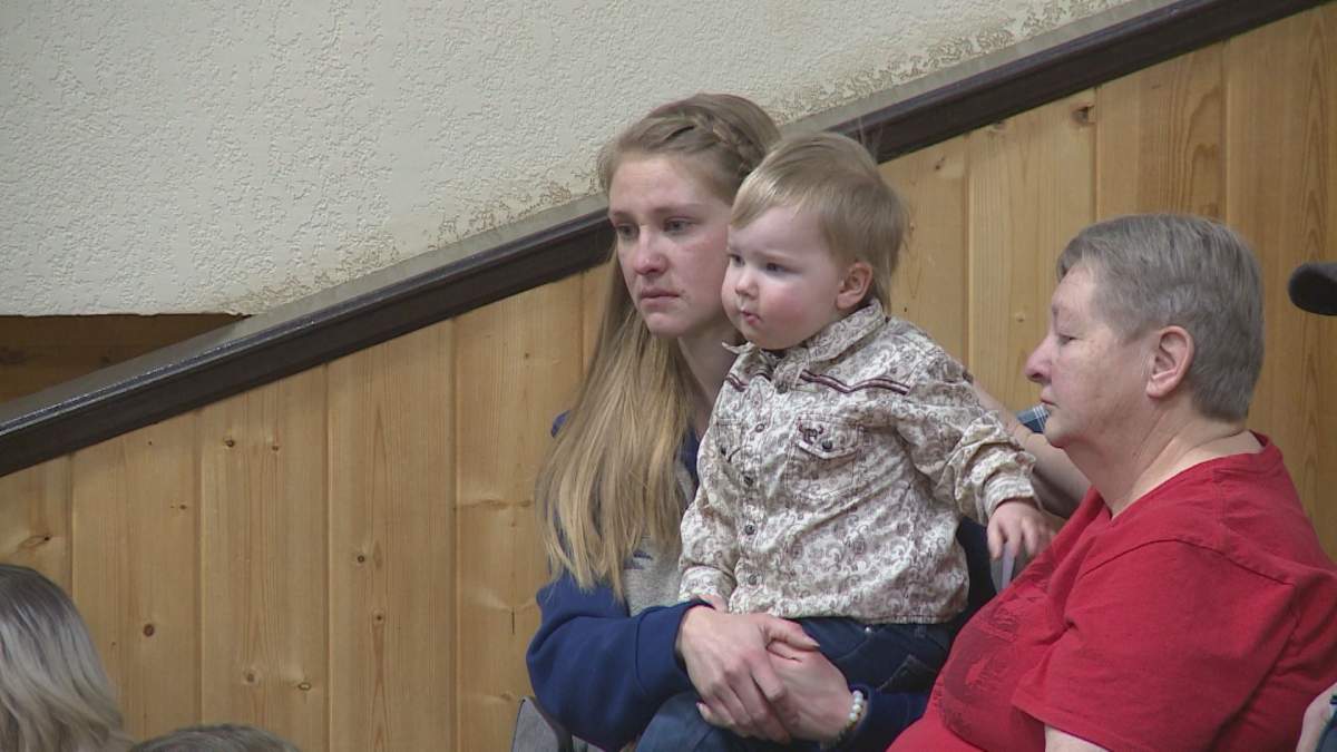 Lynn Rattai watches as her late husband’s cow is sold numerous times at auction.