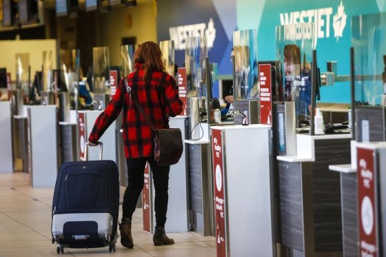 File: A passenger checks in at a Westjet counter at the Calgary Airport in Calgary, Alta., Friday, Oct. 30, 2020.