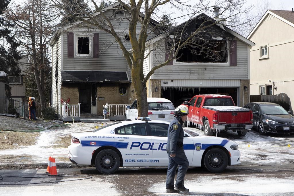 A police vehicle is parked in front of a home in Brampton, Ont., in which a family of five died in a house fire, on Monday, March 28, 2022. THE CANADIAN PRESS/Chris Young.