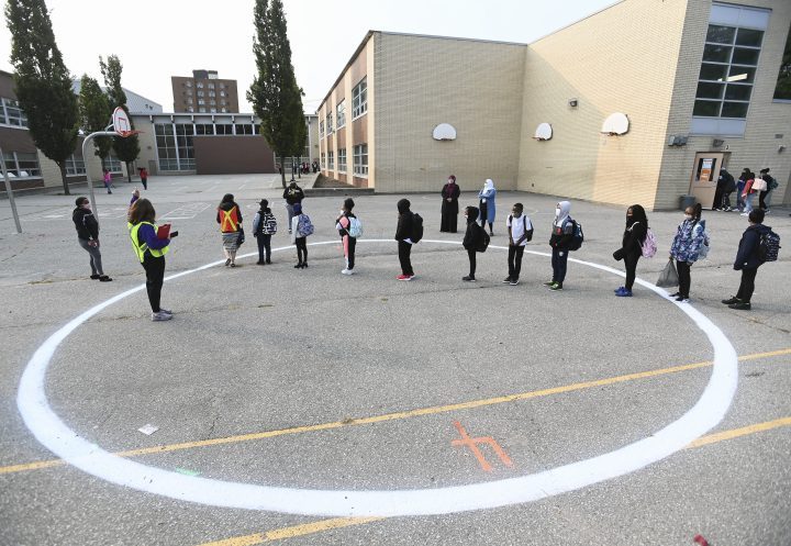Children wait in a physical distancing circle at Portage Trail Community School which is part of the Toronto District School Board (TDSB) during the COVID-19 pandemic in Toronto, Tuesday, Sept. 15, 2020. 