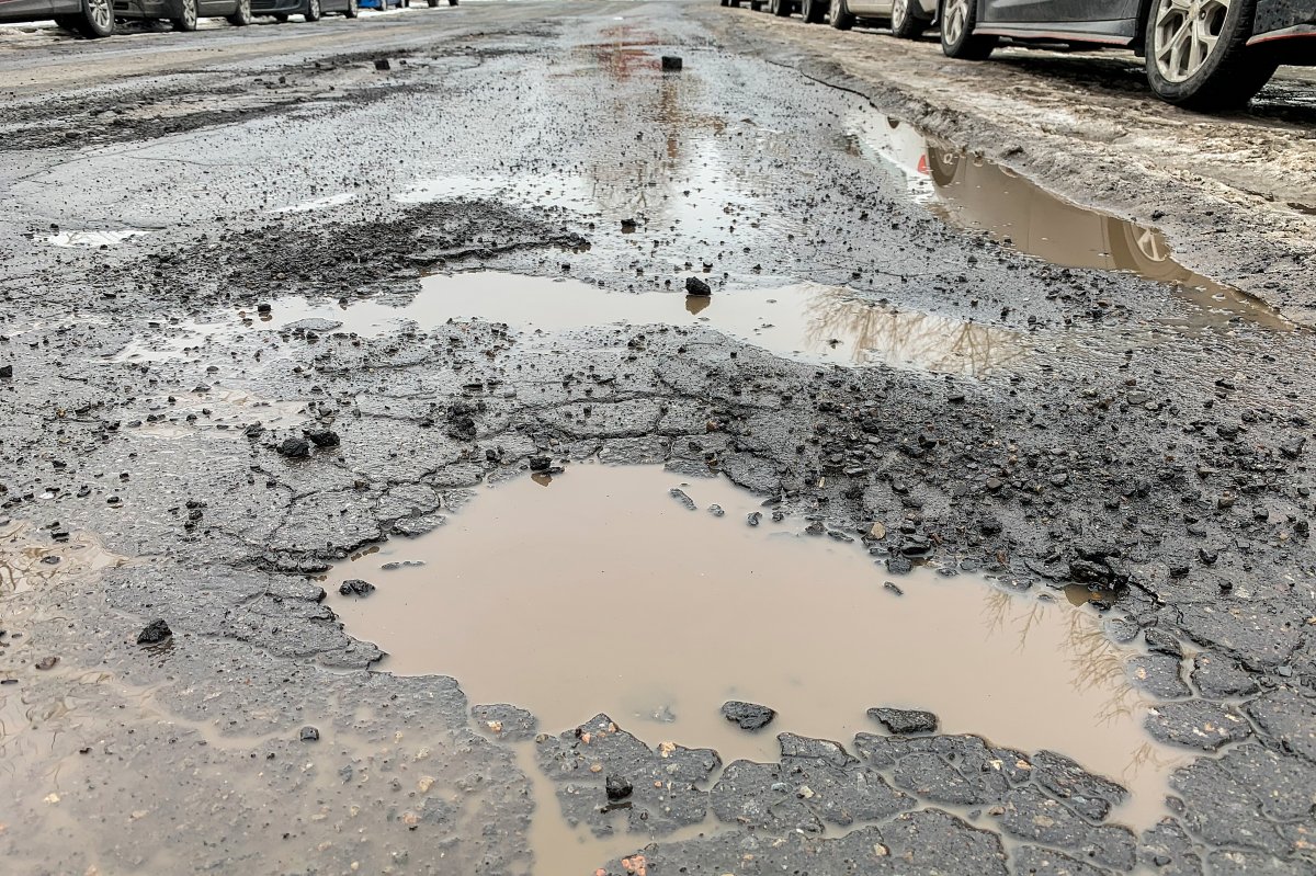 Potholes are shown on a street in Montreal, Wednesday, February 24, 2021. 
