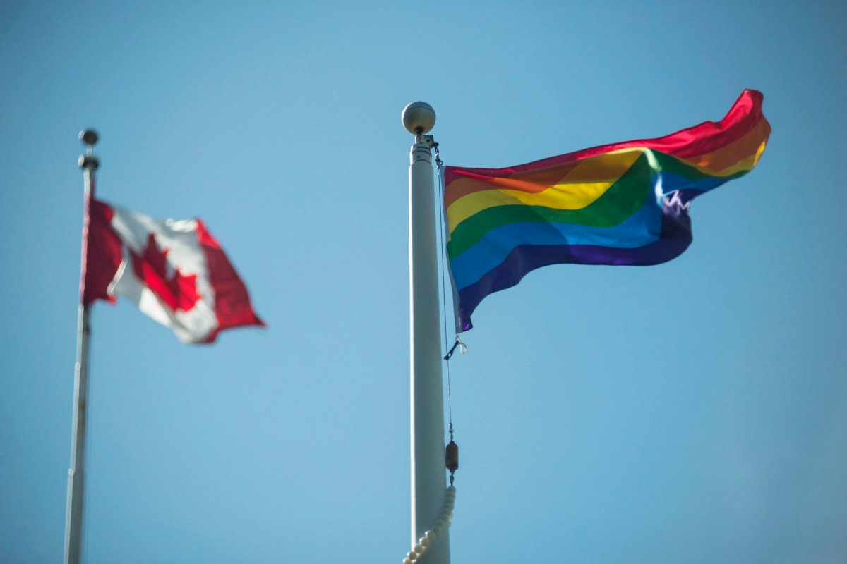The Canadian flag and the Pride flag flying next to each other.
