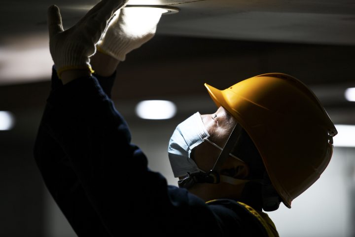 An electrician carries out lighting maintenance.