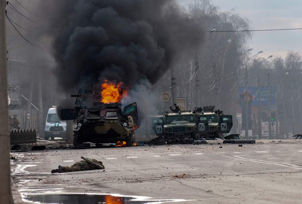 An armoured personnel carrier burns and damaged light utility vehicles stand abandoned after fighting in Kharkiv, Ukraine, Sunday, Feb. 27, 2022. THE CANADIAN PRESS-AP/Marienko Andrew
