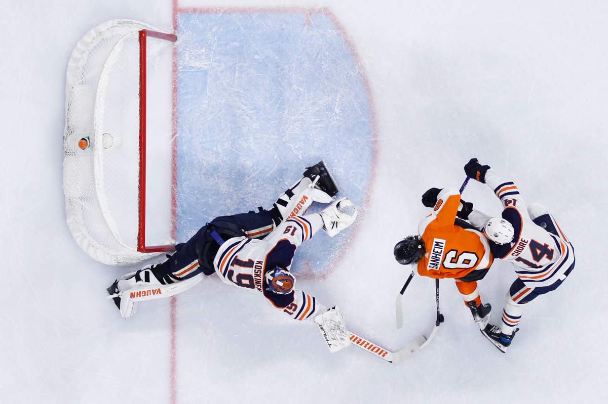 Philadelphia Flyers’ Travis Sanheim (6) cannot get a shot past Edmonton Oilers’ Mikko Koskinen (19) and Devin Shore (14) during the second period of an NHL hockey game, Tuesday, March 1, 2022, in Philadelphia. (AP Photo/Matt Slocum)