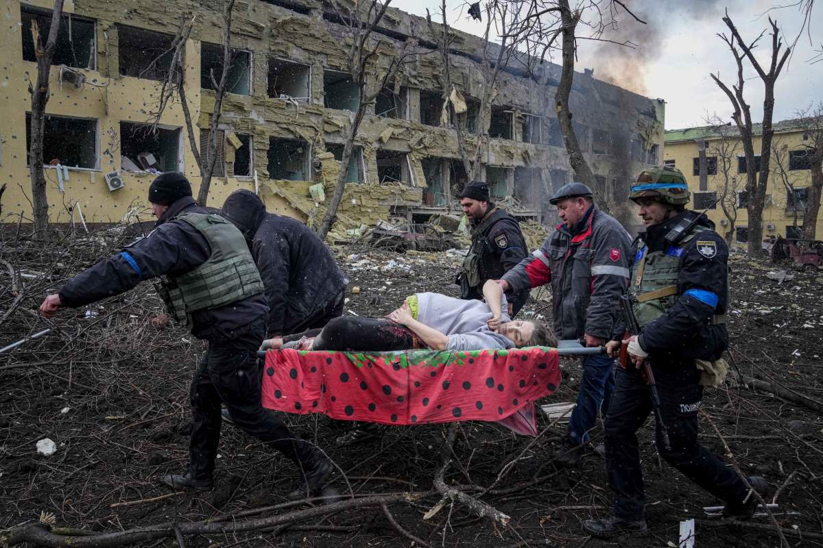 Ukrainian emergency employees and volunteers carry an injured pregnant woman from the maternity hospital that was damaged by shelling in Mariupol, Ukraine, Wednesday, March 9, 2022. A Russian attack has severely damaged the maternity hospital in the besieged port city of Mariupol, Ukrainian officials say.