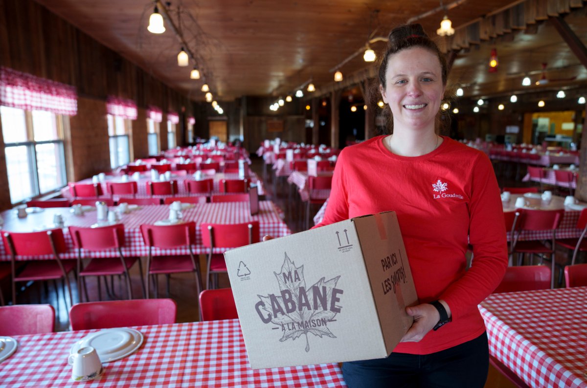 Camelie Gingras is seen holding a home delivery box in the dinning room of La Gouderelle sugar shack in Mont St-Gregoire, Que. on Thursday, March 10, 2022. Sugar shack owners across Quebec are reopening their dining rooms for the first time since the start of the COVID-19 pandemic, and strangely, they are crediting the novel coronavirus with revitalizing their industry. 
