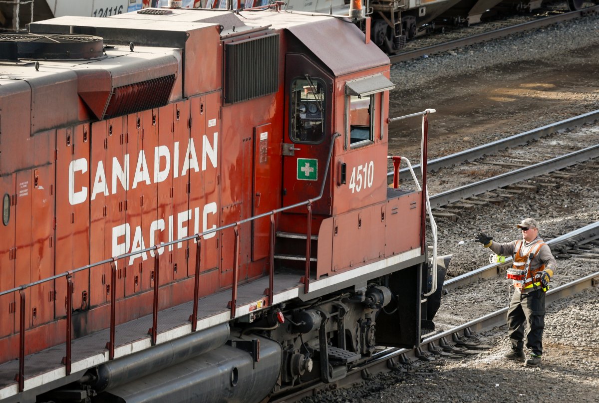 An employee boards a Canadian Pacific Railway locomotive at a yard in Calgary, Alta., Friday, March 18, 2022