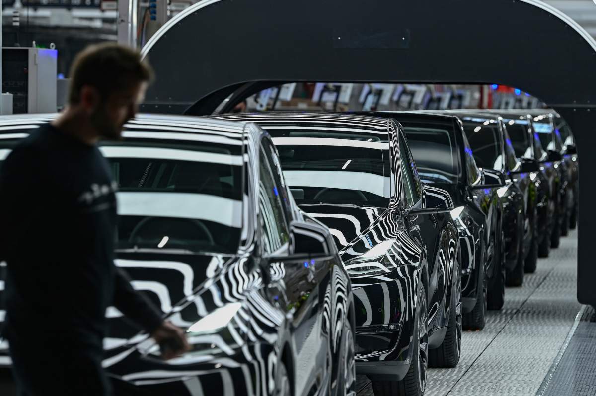 Model Y electric vehicles stand on a conveyor belt at the opening of the Tesla factory in Berlin Brandenburg in Gruenheide, Germany, Tuesday, March 22, 2022.