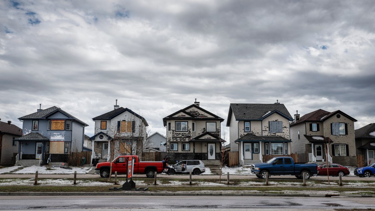 Residents survey the damage before begining cleanup in Calgary, Alta., Sunday, June 14, 2020, after a major hail storm damaged homes and flooded streets on Saturday.