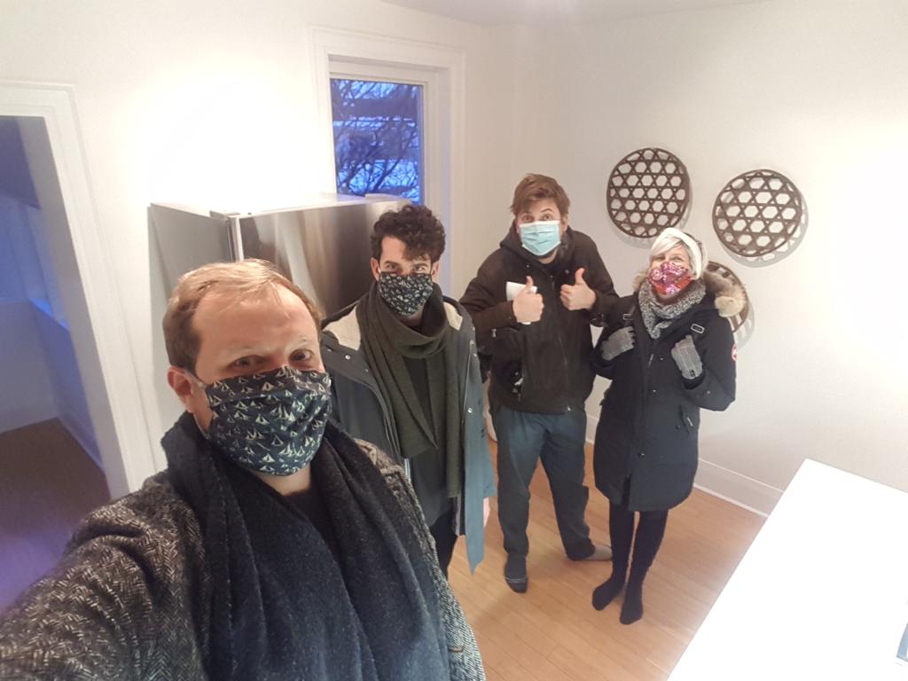 Four millennials pose for the camera inside the house they co-own.