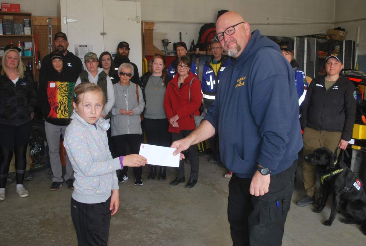 Central Okanagan Search and Rescue manager Duane Tresnich, right, accepts a cheque from family and friends of a Kelowna man who died while snowboarding at Big White Ski Resort in late December.