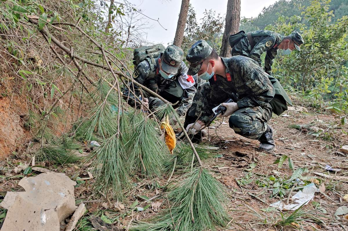 This photo taken on March 21, 2022 shows paramilitary police officers conducting a search at the site of the China Eastern Airlines plane crash in Tengxian county, Wuzhou city, in China’s southern Guangxi region.