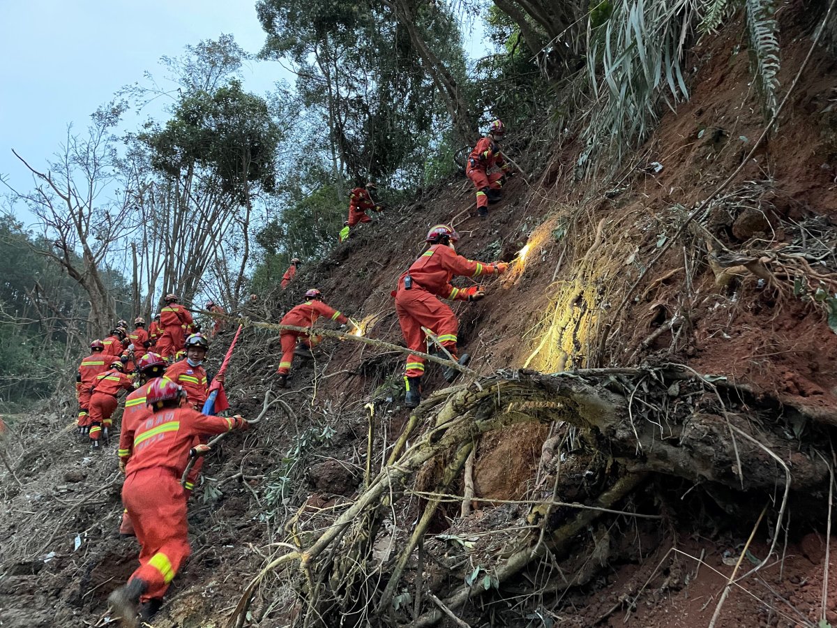 Photo taken with a mobile phone shows rescuers searching for the black boxes at a plane crash site in Tengxian County, south China’s Guangxi Zhuang Autonomous Region, March 22, 2022. Rescuers are making all-out efforts to retrieve the black boxes of a passenger plane that crashed in south China’s Guangxi Zhuang Autonomous Region Monday afternoon, an official with the Civil Aviation Administration of China CAAC said Tuesday night. The passenger plane with 132 people aboard crashed on Monday afternoon, the regional emergency management department said. The China Eastern Airlines Boeing 737 aircraft, which departed from Kunming and was bound for Guangzhou, crashed into a mountainous area near the Molang village in Tengxian County in the city of Wuzhou at 2:38 p.m., causing a mountain fire, according to the department. The airline said the cause of the accident will be fully investigated.