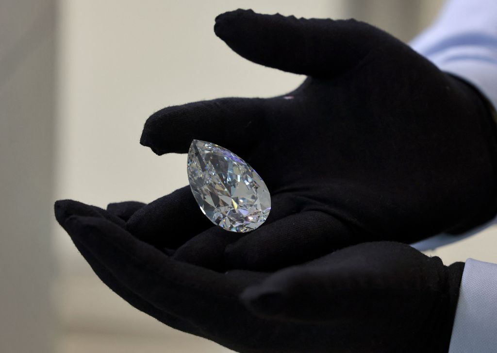 A Christie's auction house staff member cradles a giant diamond nicknamed "The Rock", in Dubai.