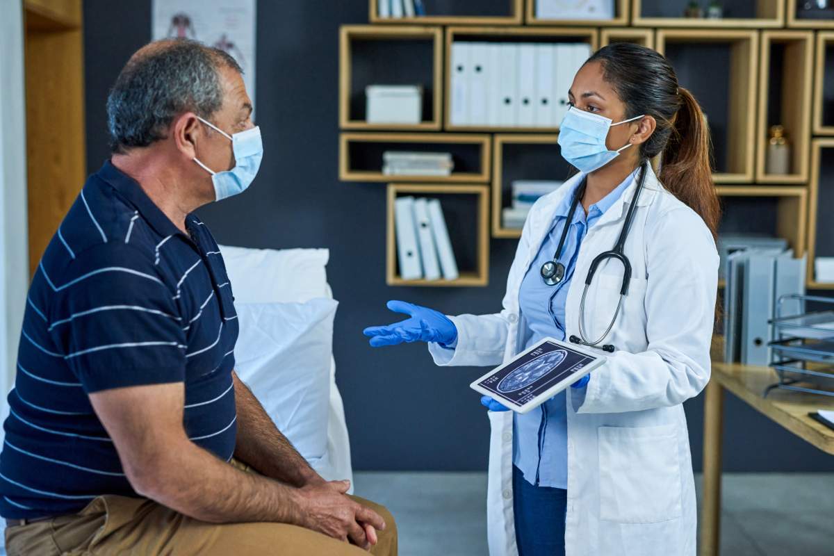 Shot of a doctor using a digital tablet to discuss a brain scan with a senior patient