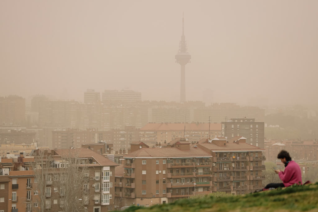 A woman observes the haze of a Saharan dust cloud from the viewpoint of Cerrro del Tio Pio.