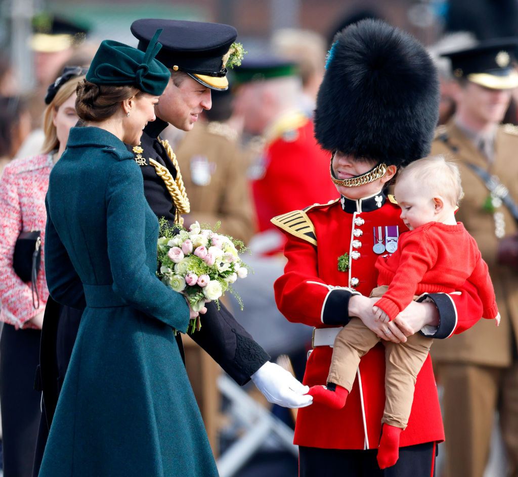 Catherine, Duchess of Cambridge and Prince William, Duke of Cambridge talk with an Irish Guardswoman and toddler during the annual St. Patrick's Day parade at Mons Barracks on March 17, 2022 in Aldershot, England.