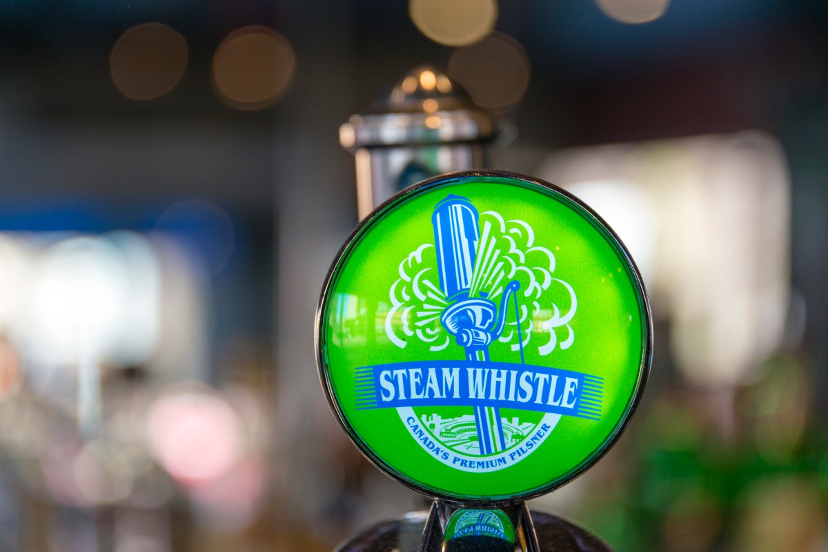 TORONTO, ONTARIO, CANADA - 2016/04/27: Steam Whistle beer tap handle, green design with company's logo. The company produces a premium pilsner lager packaged in distinctive green glass bottles and a non-twist ca. (Photo by Roberto Machado Noa/LightRocket via Getty Images).