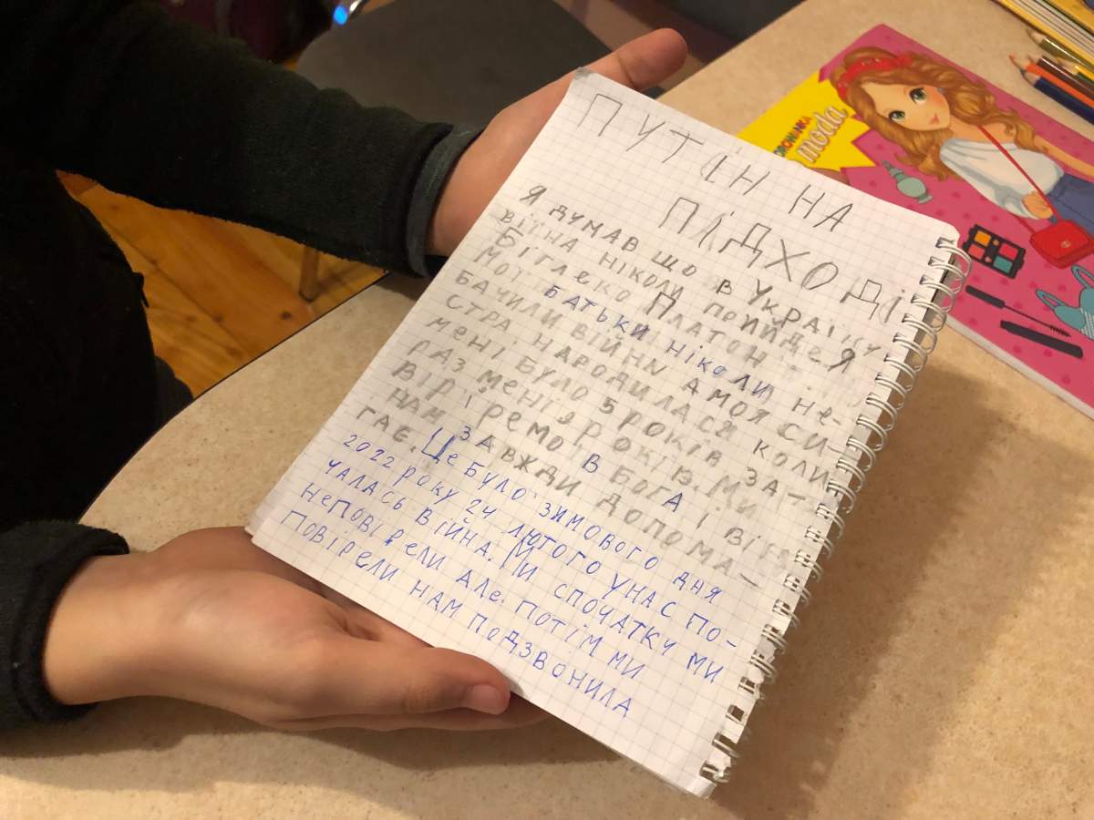 Platon Bihlenko, 9, shows a story he wrote about his family’s escape from Ukraine.