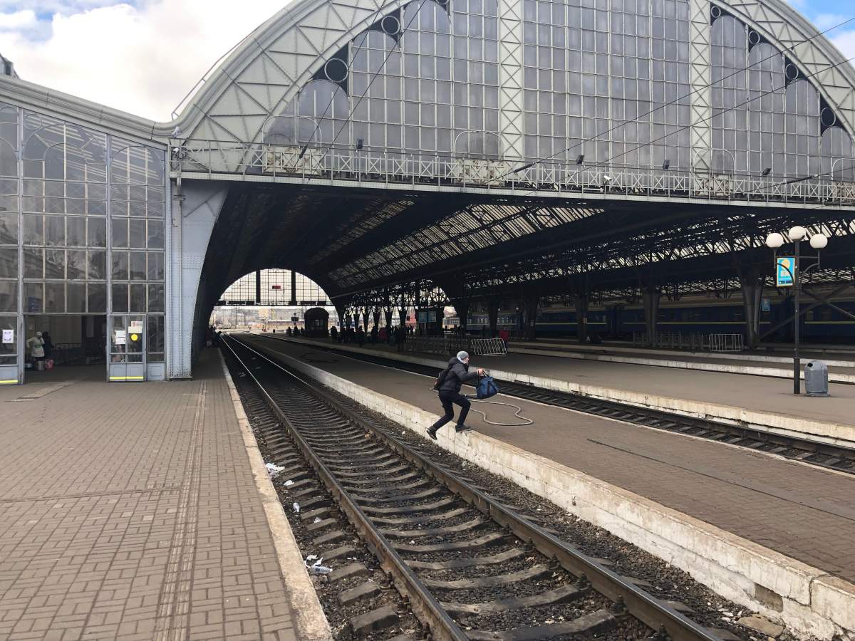 A passenger hops tracks at Lviv Railway Station, March 8, 2022.