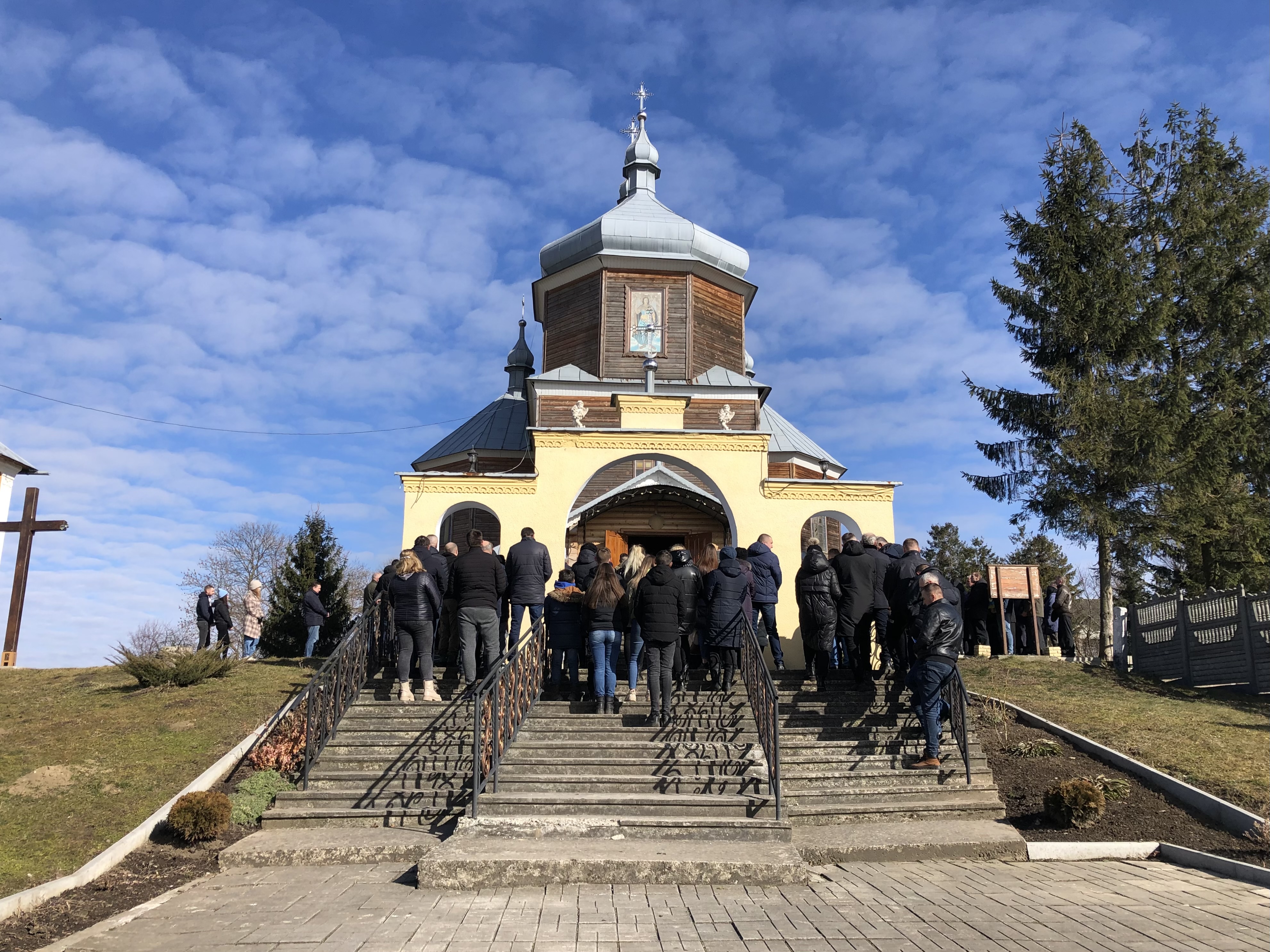 Mourners gather outside village church in western Ukraine to pay respects to fallen soldier, March 9, 2022.