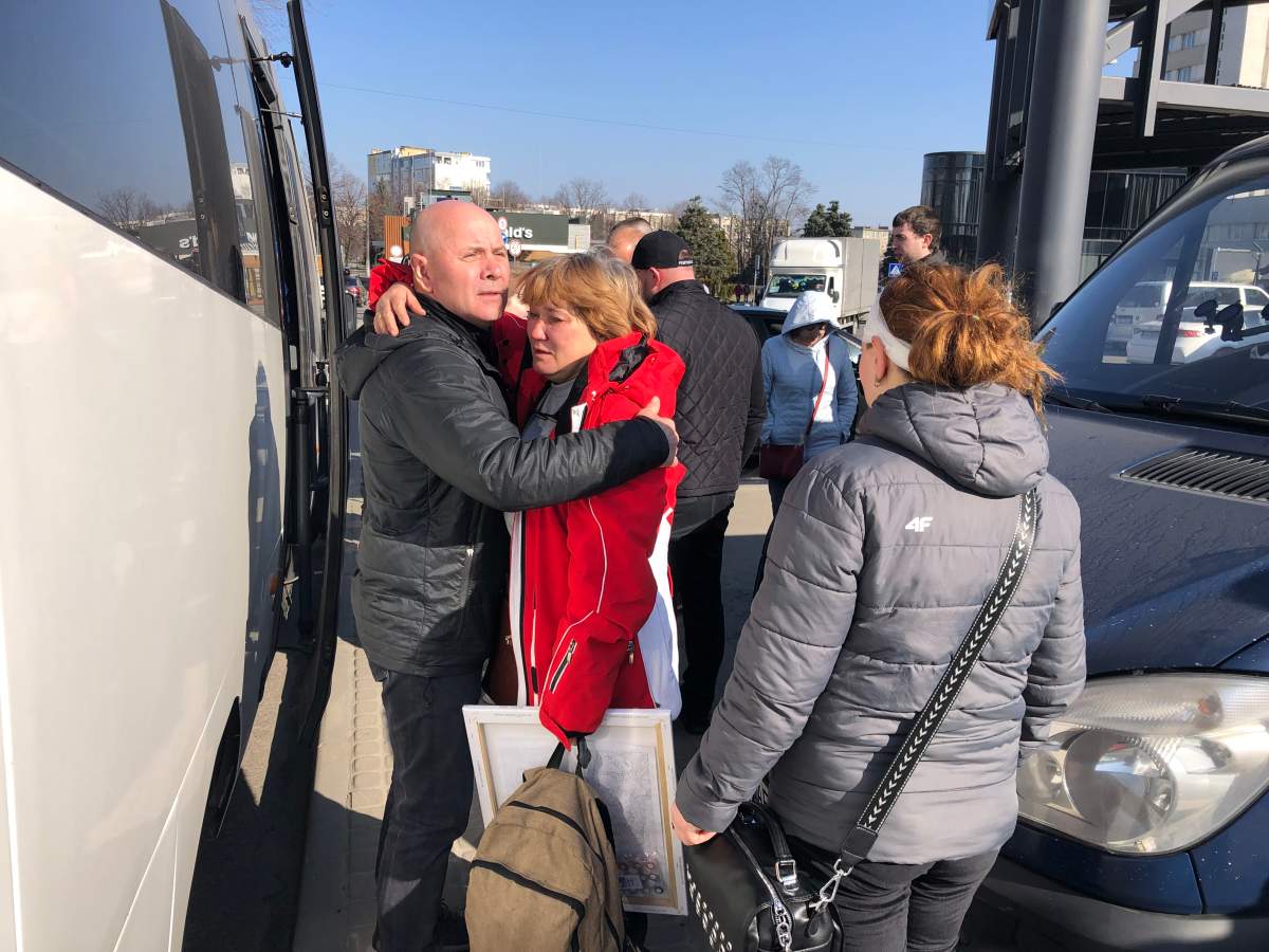 Galuna, in the red coat, says goodbye to her family before boarding the bus to Poland, March 26, 2022.