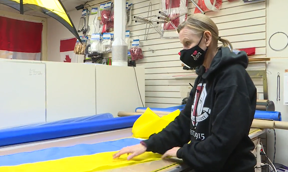 Maggie Rennick makes Ukrainian flags at The Flag Shop Victoria on March 2, 2022. Demand for Ukrainian flags has outstripped the store's capacity to make them since Russia launched its full-scale invasion last week, said Rennick.