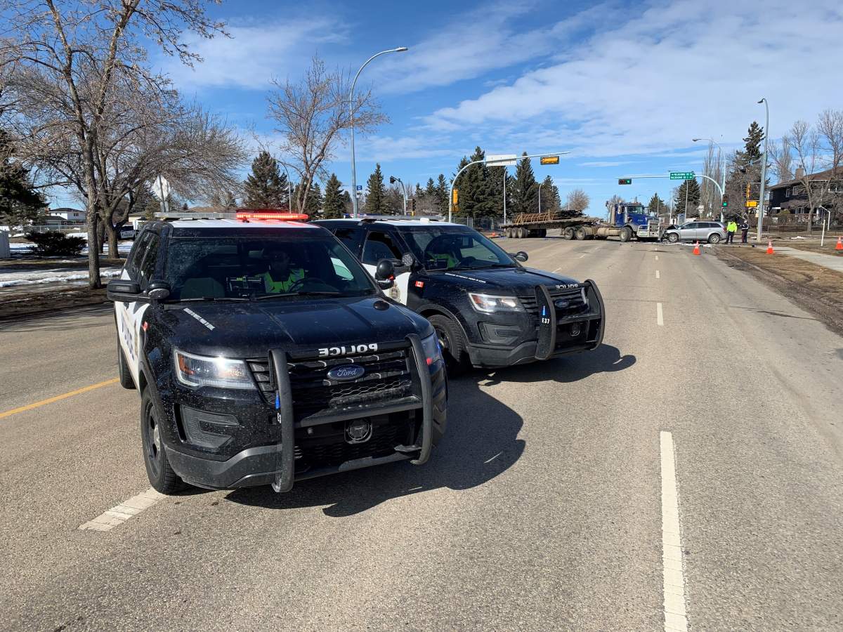 Edmonton Police Service members at the scene of a head-on collision between a semi and an SUV at the intersection of Millbourne Road East and 76 Street in Mill Woods on Monday, March 21, 2022.