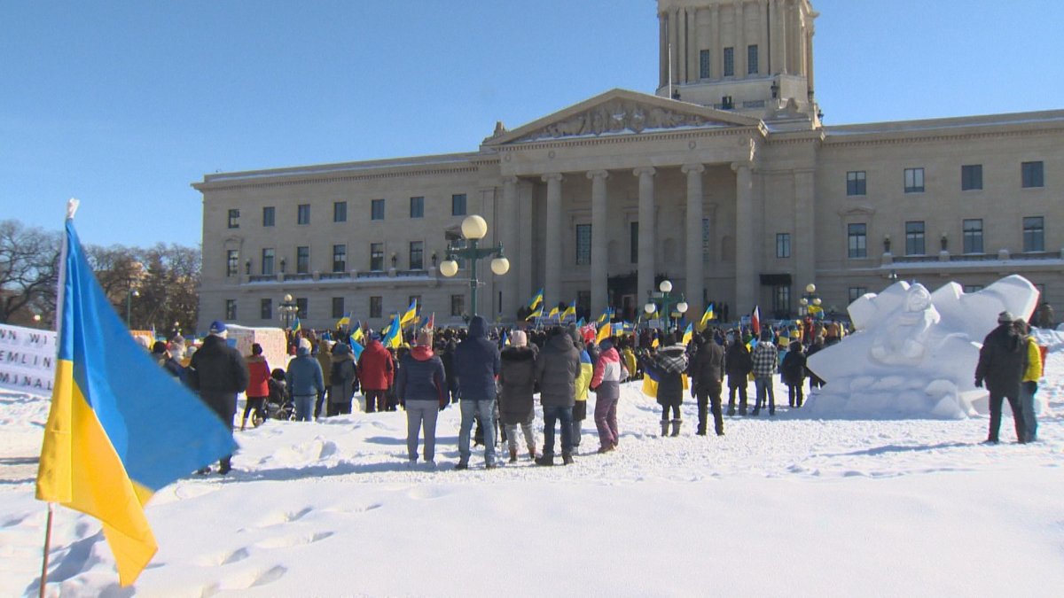 People gathered wearing colours of Ukraine's flag at the Manitoba Legislative Building to show support for Ukraine.