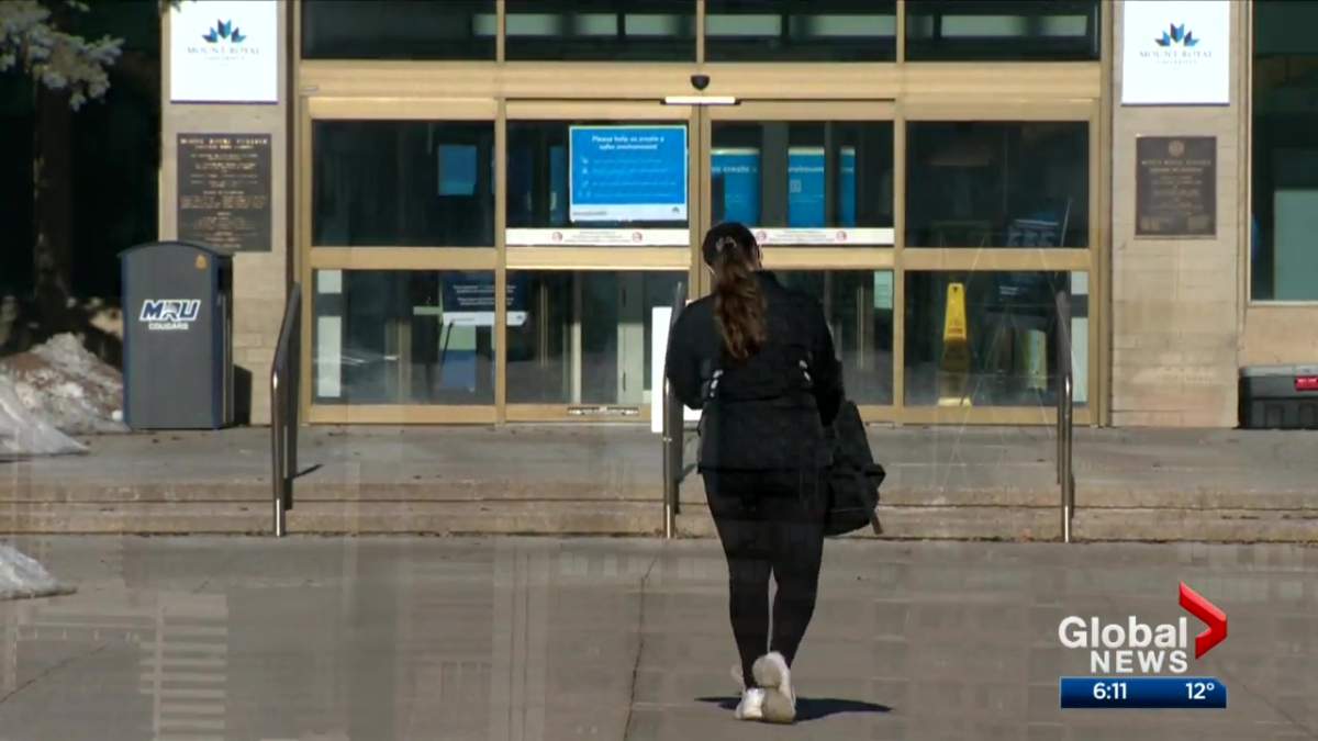 A woman walks into Mount Royal University on March 22, 2022.