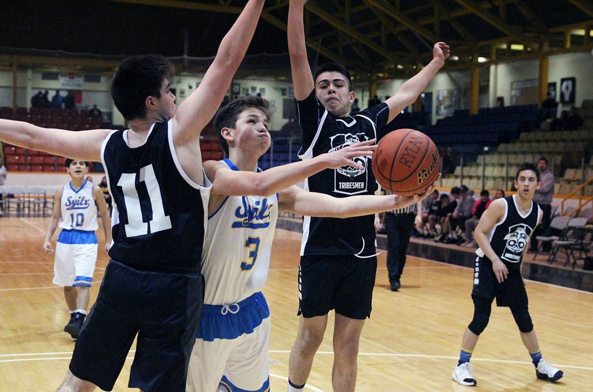 Close up of basketball players one is trying to make a shot.