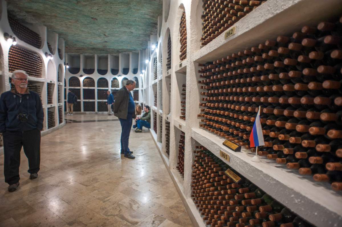 CRICOVA WINERY, CRICOVA, MOLDOVA - 2017/05/22: Tourists admiring the wine cellars of Cricova Winery, Moldovas second largest wine cellar with over 120km of underground roadways. On the right side is the private collection of Vladimir Putin.