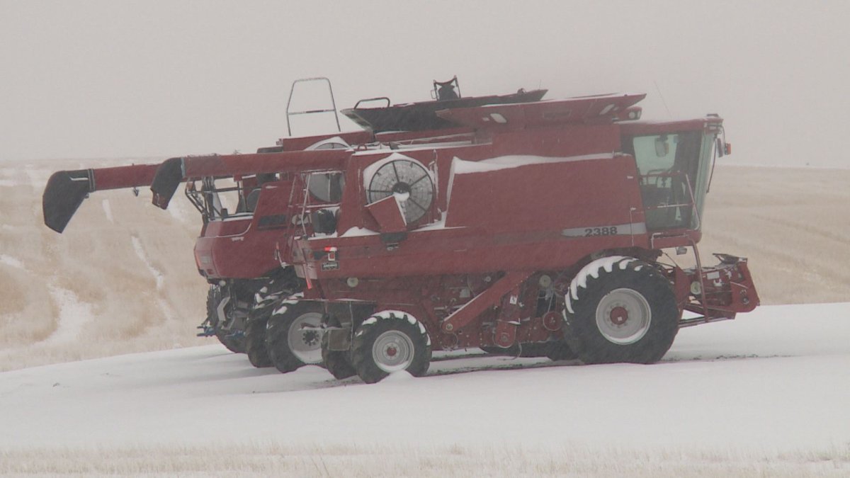 Snow falls on some combines in southern Alberta.