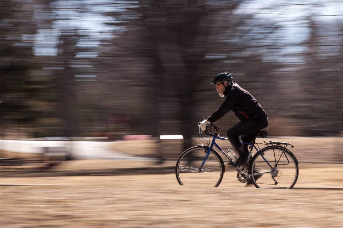 FILE - A man bikes in London's Springbank Park on March 26, 2018. 