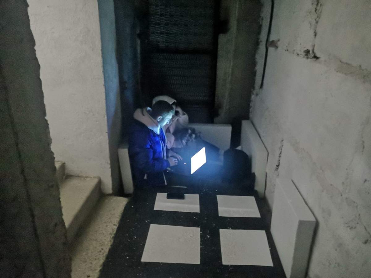 People use a laptop from their shelter in Kamianets-Podilskyi in southwestern Ukraine on March 15, 2022.